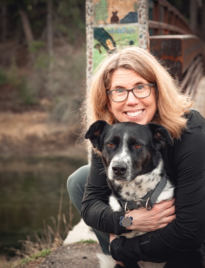 Kimberly Fisher hugging her black-and-white dog
